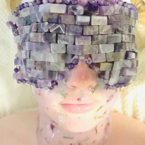 An amethyst crystal eye mask and floral facial treatment in progress at Tulum Spa